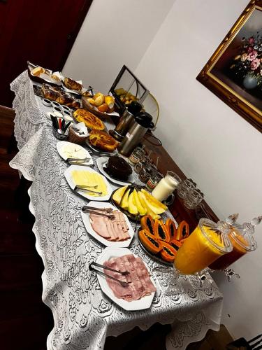 een tafel met borden met voedsel en fruit bij Pousada dos Pássaros in Camanducaia