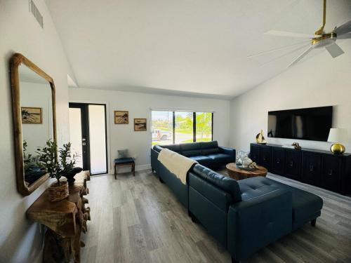 a living room with a blue couch and a tv at Marco Island Lifeisgood Home ! in Marco Island