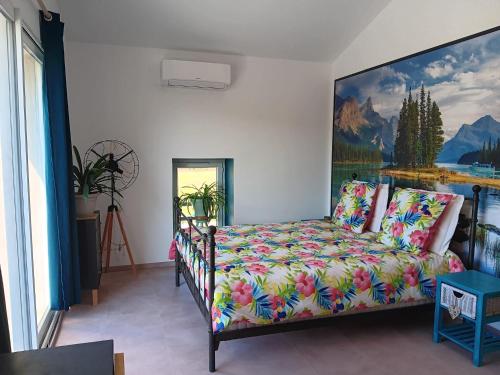 une chambre avec un lit et un tableau au mur dans l'établissement La Batisse, à Livron-sur-Drôme