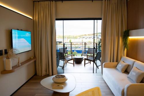 a living room with a couch and a tv at Morro dos Anjos Águas Quentes Hotel Resort in Bandeirantes