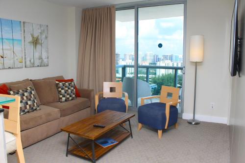 a living room with a couch and chairs and a table at Marenas LATERAL ocean view daily refresh not included Fees collected at arrival in Sunny Isles Beach