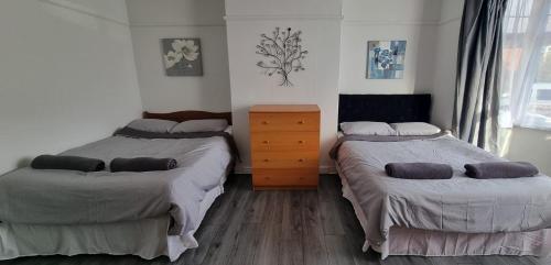 a bedroom with two beds and a dresser at Tyne Relaxation in Newcastle upon Tyne