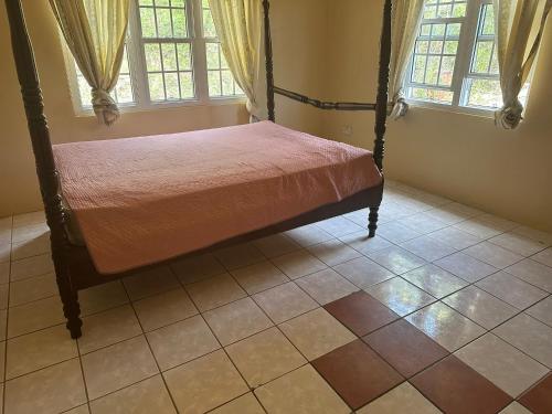 une chambre avec un lit dans une pièce avec des fenêtres dans l'établissement Spacious 4-Bedroom Island Home Near Jolly Harbour Beaches, à Bolans