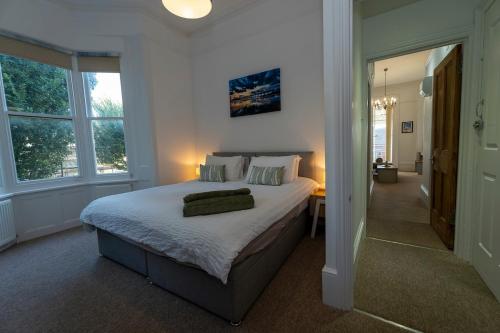 a bedroom with a large bed in a room with windows at Spacious 2 Bed Apartment in Brighton- Free Parking in Brighton & Hove