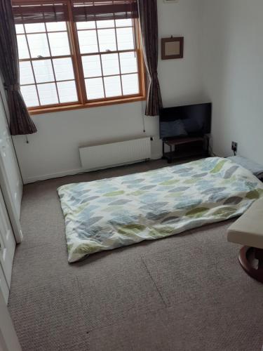 a bedroom with a bed in the middle of the room at ゲストハウス苫小牧 204号室 in Tomakomai
