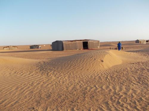 a man standing in the sand in the desert at Bivouac Draa in Zagora