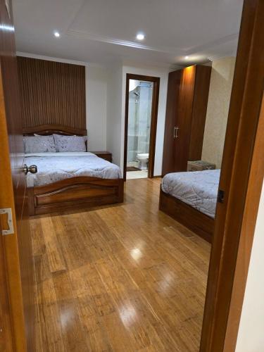 a bedroom with two beds and a wooden floor at La suite del ensueño in Cuenca