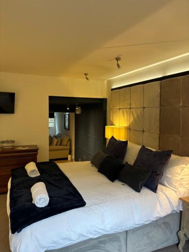 a bedroom with a large white bed with black pillows at Otter Hollow - a spacious central apartment in Middleton