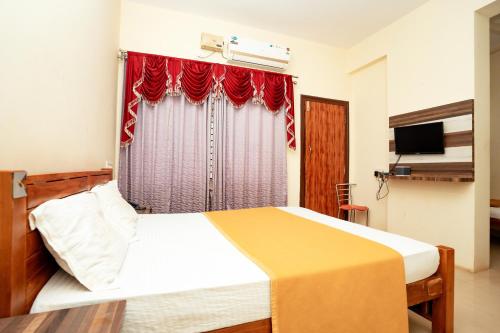a bedroom with a bed with a red curtain at Kukke Sai Skanda in Subrahmanya