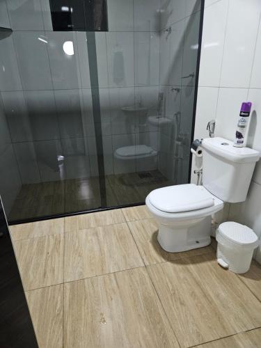 a bathroom with a toilet and a shower at Refúgio GRUPOS com piscina, churrasqueiras 38 min Águas Claras Brasília in Brasília