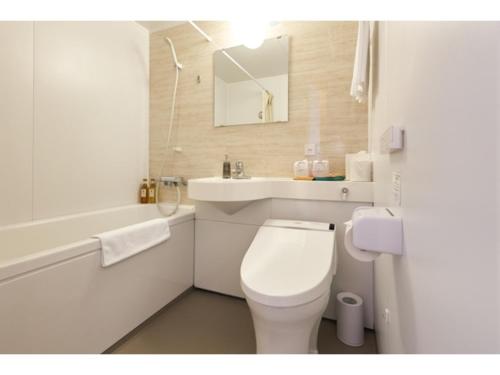 a white bathroom with a toilet and a sink at Smile Hotel Miyakojima - Vacation STAY 93494v in Miyako Island
