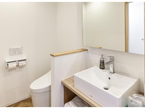 a white bathroom with a sink and a toilet at Smile Hotel Miyakojima - Vacation STAY 93496v in Miyako Island