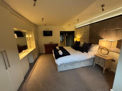 a bedroom with a large bed and a table with a lamp at Otter Hollow - a spacious central apartment in Middleton