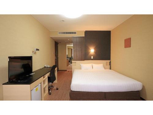 a hotel room with a bed and a desk with a television at Smile Hotel Otsu Seta - Vacation STAY 00125v in Zeze-Awazumachi
