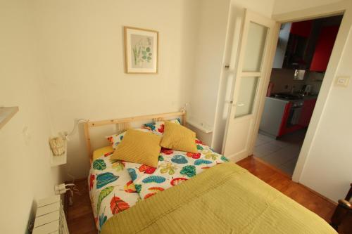 małą sypialnię z łóżkiem z żółtymi poduszkami w obiekcie Apartment Keglich w Zagrzebiu