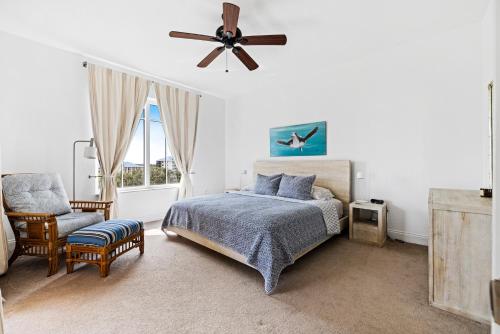 a bedroom with a bed and a fan and a chair at Spacious Gated Minorca Retreat, Pet Friendly with Pond Views and Resort Amenities - MM403 in Isleboro