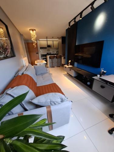 Schlafzimmer mit einem großen Flachbild-TV und einem Bett in der Unterkunft Smart Residence Praia in Maceió
