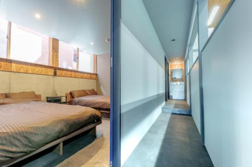 a bedroom with a bed and a hallway at Casa CarpeDiem - Vacation STAY 09135v in Ichinomiya