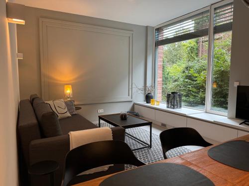 a living room with a couch and a window at Cozy apartment in new building in Hamburg