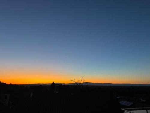 a view of the sunset from the roof of a house at Haus am Vogesenblick - Ihr Zimmer mit Aussicht in Bad Bellingen