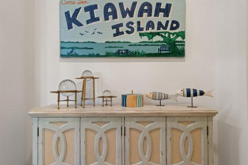 a wooden cabinet with various items on top of it at 19 Eugenia Avenue by Akers Ellis Rentals in Kiawah Island