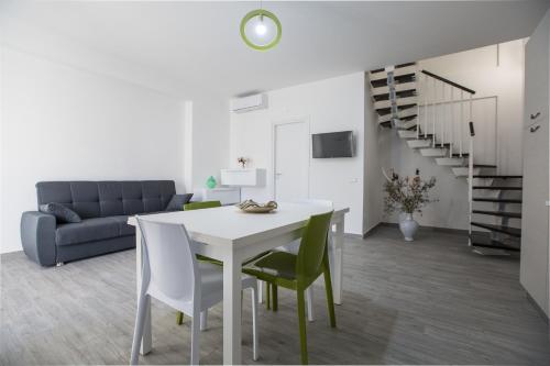 - un salon avec une table, des chaises et un canapé dans l'établissement Le Terrazze in Villa, à Reitano