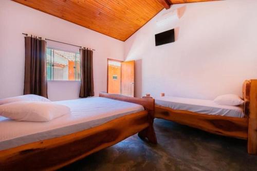 a bedroom with two beds and a window at chacara joao de barro in Pirenópolis