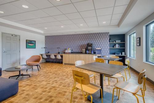 a waiting room with tables and chairs and a counter at Best Western Byron Center in Byron Center