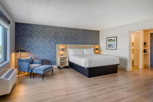 a hotel room with a bed and a chair at Best Western Byron Center in Byron Center