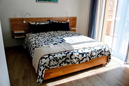a bedroom with a bed with a black and white comforter at Vento del Brenta House in Pove del Grappa
