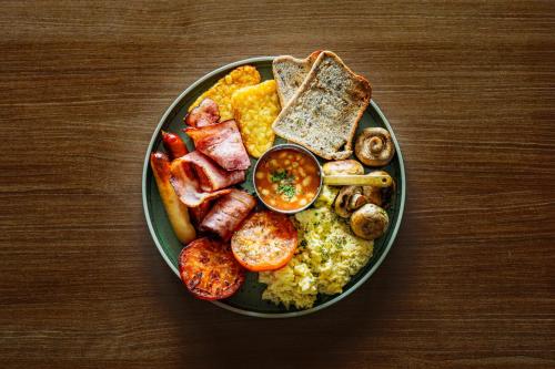 un plato de desayuno en una mesa de madera en Holiday Inn Auckland Airport by IHG, en Auckland