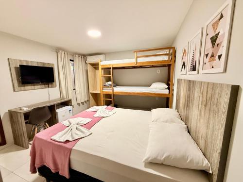 a bedroom with a bed and a bunk bed at Summer Suítes - Passagem in Cabo Frio
