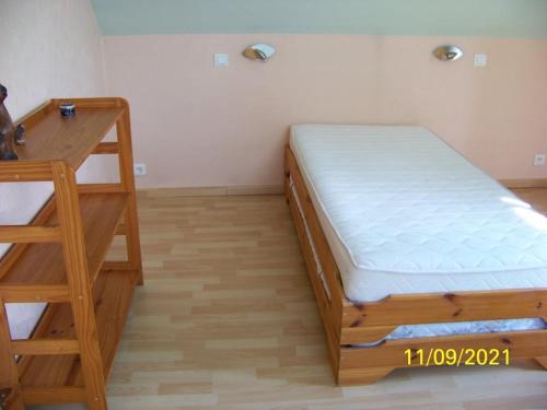 a bedroom with a wooden bed and a desk at La Salamandre in Écouflant