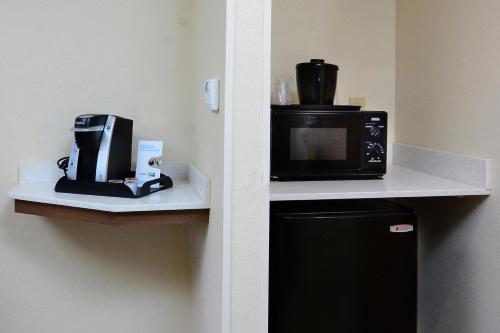 a kitchen with a coffee maker and a microwave on a shelf at Holiday Inn Express & Suites Raleigh Durham Airport at RTP by IHG in Durham