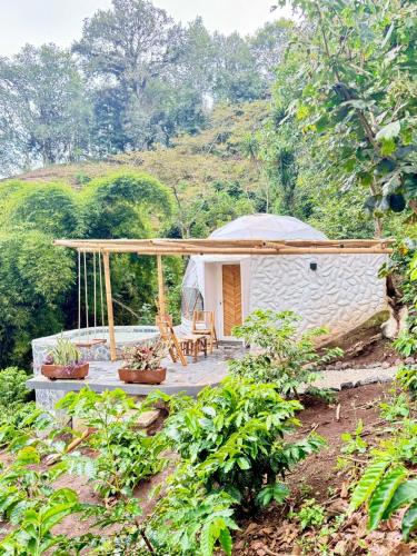 a small white building with a porch in a forest at Alma Glamping in Xalapa