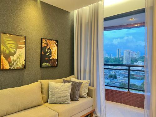 ベレンにあるComfortable 2BR Apt in Belém Best Areaのソファと大きな窓のあるリビングルーム