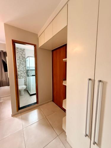 a bathroom with a toilet and a mirror at Summer Suítes - Passagem in Cabo Frio