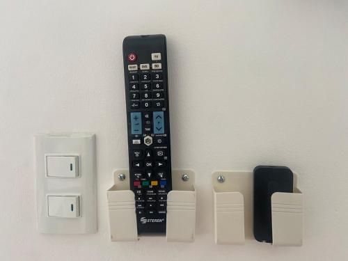 a remote control hanging on a wall next to switches at Residence in Cuautla 