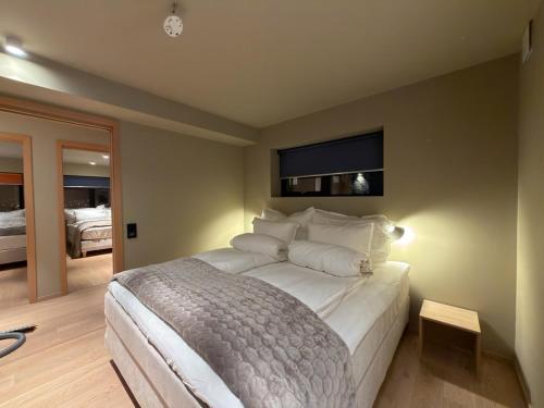 a bedroom with a large white bed with a window at Aurora Panorama in Tromsø