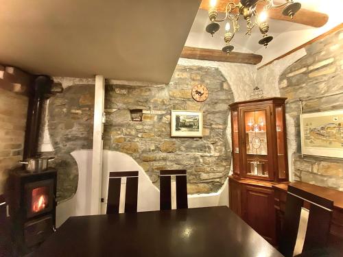 a dining room with a table and a stone wall at Vojko Holidays in Koper
