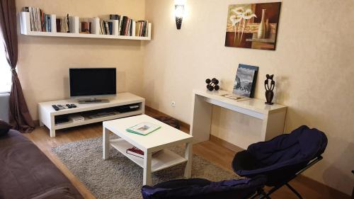 a living room with a tv and a table and chairs at Gîte le Lynx in Passenans