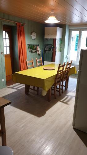 a kitchen with a yellow table and chairs at Gîte le Lynx in Passenans