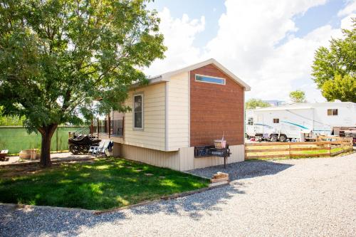 a small house with a tree and a trailer at JW Grand Junction in Grand Junction