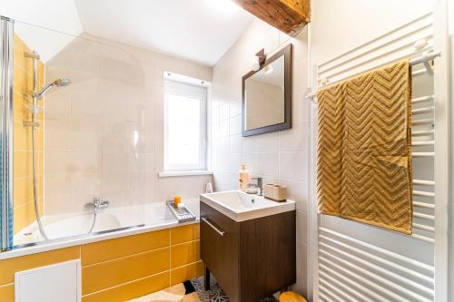 a bathroom with a sink and a tub and a mirror at Le Nid - Hypercentre - 3 beds - Wifi - Netflix in Cambrai