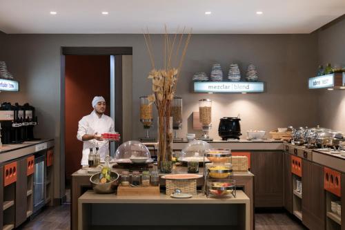 un chef de pie en una cocina con barra en Hampton by Hilton Barranquilla, en Barranquilla