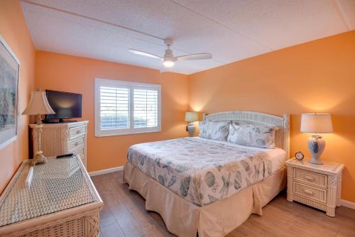 een slaapkamer met een bed en een flatscreen-tv bij Resort Condo Steps to Beach Snowbirds Welcome! in Saint Augustine Beach