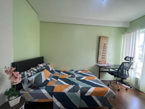 a bedroom with a bed and a desk and a chair at 1BR Condo w Pool & Balcony Near Robinson Place - F&M Homes - Sitio Uno Residences, Pueblo de Panay in Roxas City