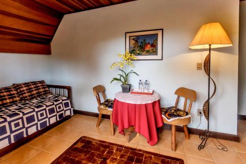 a bedroom with a table and chairs and a bed at Pousada Sotaque Mineiro in Cunha