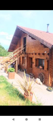 a large wooden house with a staircase in front of it at studio Nature & détente in Puessans