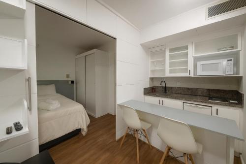 a small kitchen with a bed and a table and chairs at Hotel Av Ibirapuera 2534 Moema São Paulo 1102 in Sao Paulo